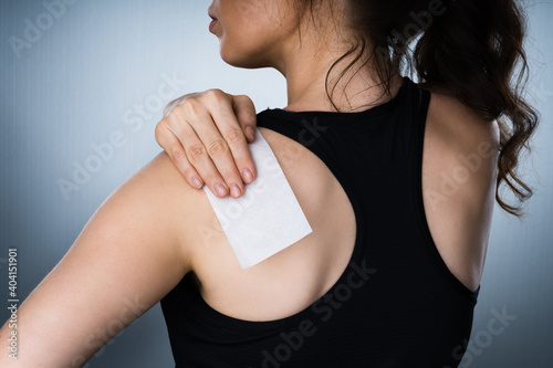 Obraz na plátně Woman Applying Stiff Shoulder Pain Patch