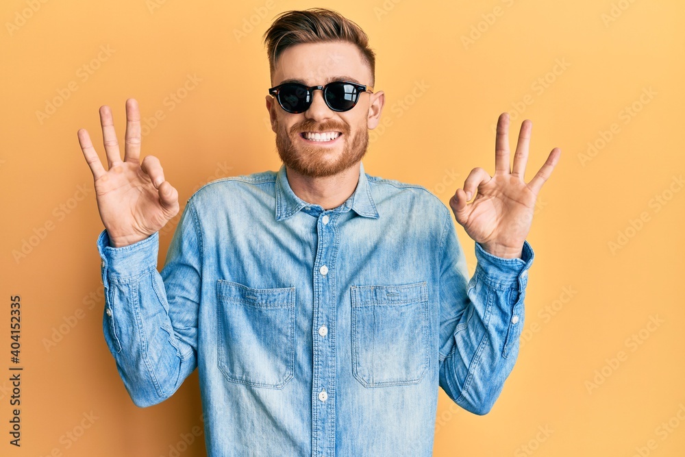 Naklejka premium Young redhead man wearing stylish sunglasses relax and smiling with eyes closed doing meditation gesture with fingers. yoga concept.