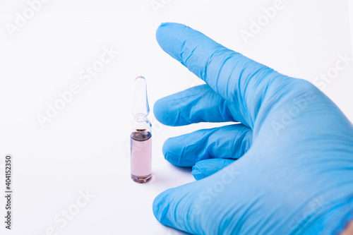 Medicine in ampoule. Vaccination. Glass ampoule in the medic's hand.