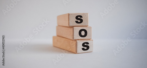 inscription sos on wooden cubes on white background