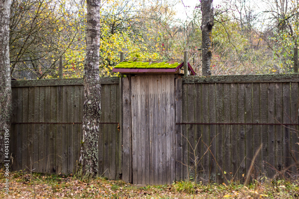Wooden fence with a gate at a summer cottage Wooden fence with a gate at a summer cottage