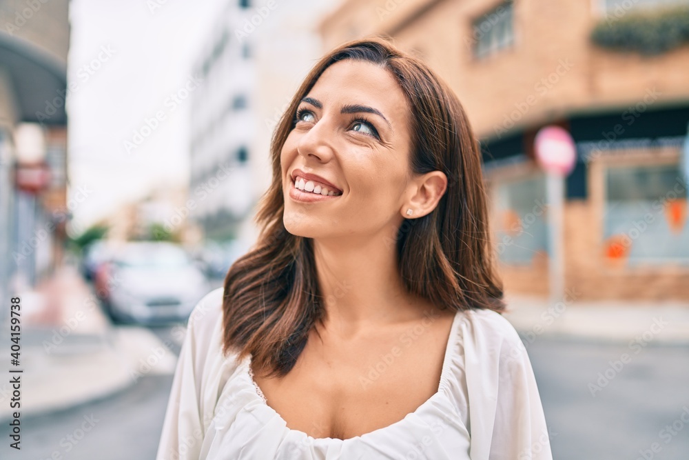 Young hispanic woman smiling happy walking at the city.