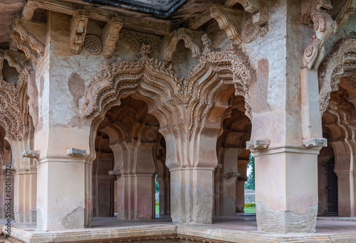 Hampi, Karnataka, India - November 5, 2013: Zanana Enclosure. Corner detail of brown and gray stone extensively decorated peacock arches over entrance gates. 