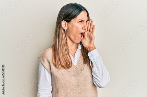 Brunette young woman wearing casual clothes shouting and screaming loud to side with hand on mouth. communication concept.