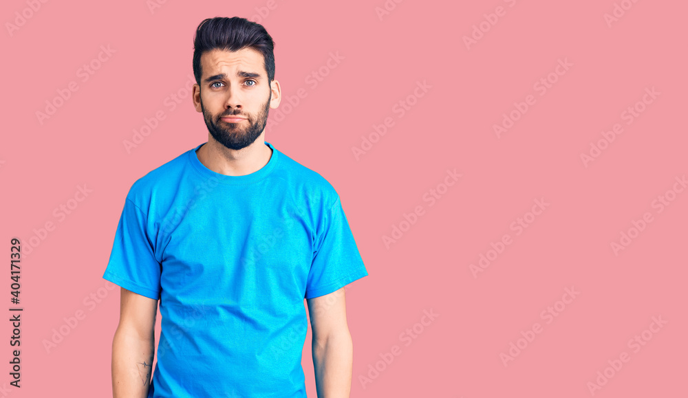 Young handsome man with beard wearing casual t-shirt depressed and worry for distress, crying angry and afraid. sad expression.