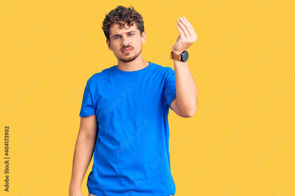 Young handsome man with curly hair wearing casual clothes doing italian gesture with hand and fingers confident expression Young handsome man with curly hair wearing casual clothes doing italian gesture with hand and fingers confident expression
