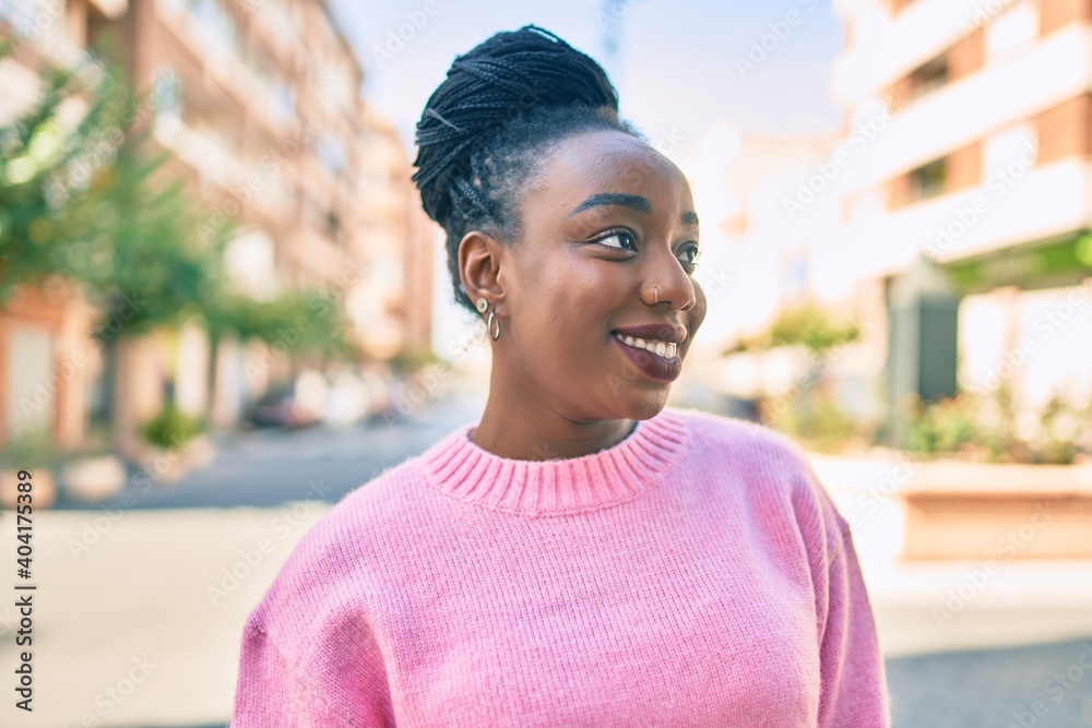 Fototapeta premium Young african american woman smiling happy walking at the city.