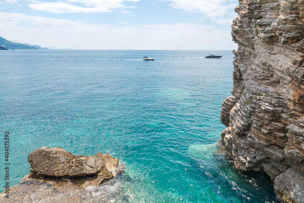 Naklejka premium Two boats near rocky steep sea coast