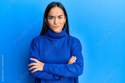 Young asian woman wearing casual winter sweater skeptic and nervous, disapproving expression on face with crossed arms. negative person. © Krakenimages.com