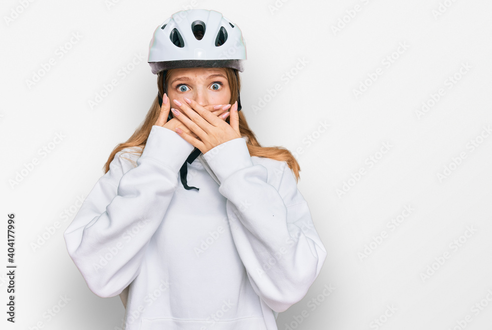 Beautiful young caucasian girl wearing bike helmet shocked covering mouth with hands for mistake. secret concept. Beautiful young caucasian girl wearing bike helmet shocked covering mouth with hands for mistake. secret concept.