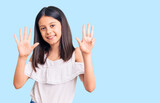 Beautiful child girl wearing casual clothes showing and pointing up with fingers number nine while smiling confident and happy.