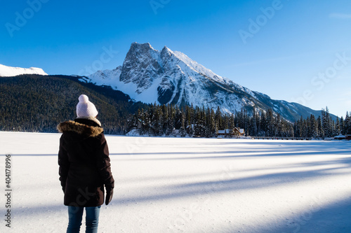 Back view of a woman admiring the winter scenery at Emerald Lake, in Yoho National Park, Canada