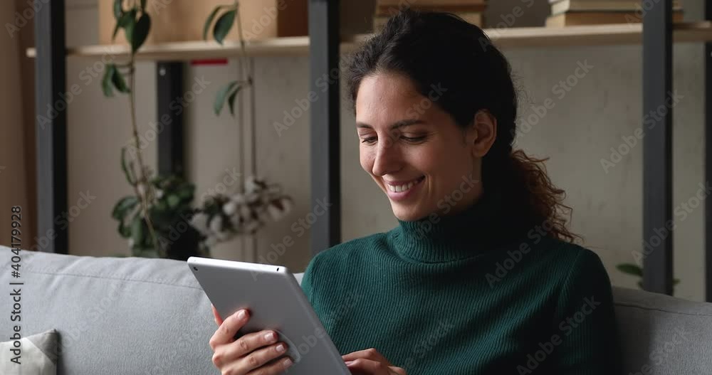 Smiling woman relaxing on weekend at home with tablet device on couch. Enjoy new app, buy on internet, make easy order on-line using modern gadget, ecommerce retail services satisfied customer concept Smiling woman relaxing on weekend at home with tablet device on couch. Enjoy new app, buy on internet, make easy order on-line using modern gadget, ecommerce retail services satisfied customer concept