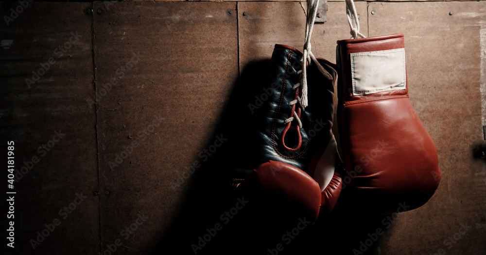 Classic, leather, oldschool, red boxing gloves hanging on the wall. Vintage, retro style.