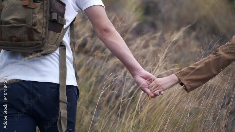 Close up of Asian couple holding hands hiking and climbing together on mountain hill. Happy man and woman relax and enjoy travel and summer outdoor lifestyle with beautiful nature on holiday vacation. Close up of Asian couple holding hands hiking and climbing together on mountain hill. Happy man and woman relax and enjoy travel and summer outdoor lifestyle with beautiful nature on holiday vacation.