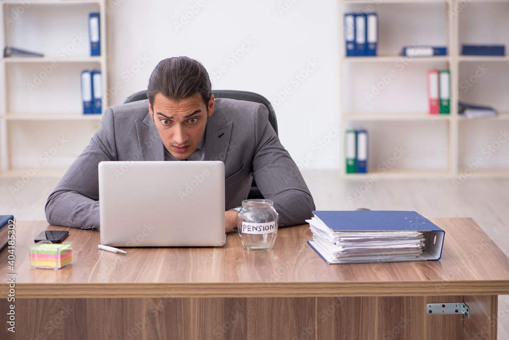 Young male employee in pension concept at workplace Young male employee in pension concept at workplace
