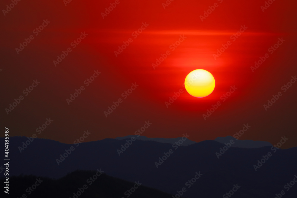 sunset on evening sky over silhouette dark mountain and clear red sky