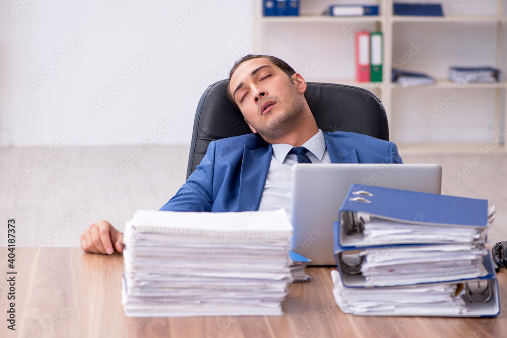 Young male employee unhappy with excessive work Young male employee unhappy with excessive work