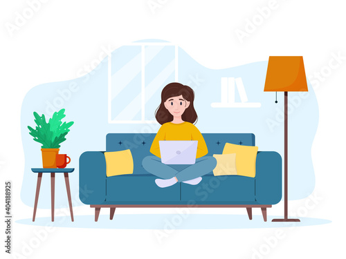 Woman working on laptop at home on the couch. Freelance or studying concept. Work from home.