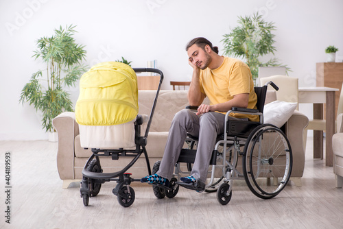 Young man contractor in wheel-chair looking after newborn