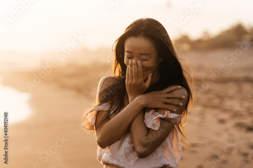 Smile Freedom and happiness chinese woman on beach. She is enjoying serene ocean nature during travel holidays vacation outdoors. asian beauty. summer time #404192148