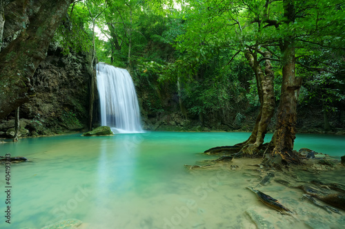 waterfall clear emerald water or blue pool and pond on summer season with rock and tree roots for holiday relax travel in green jungle or forest at erawan waterfall floor 3 for nature landscape