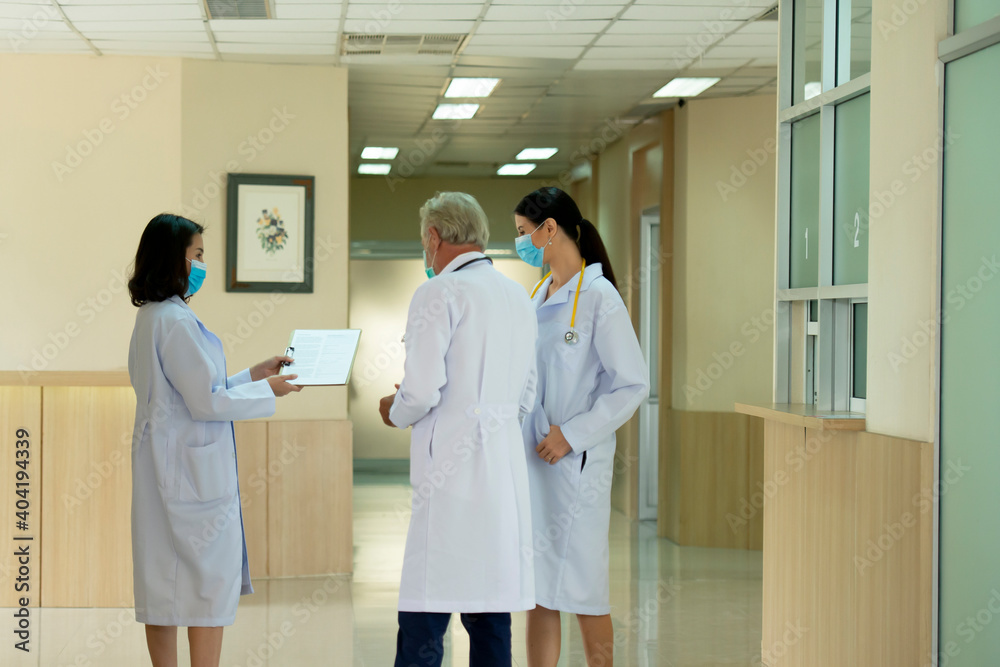 Doctors team wearing mask consult while walking at hospital Doctors team wearing mask consult while walking at hospital