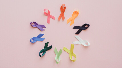 all color ribbons on pink background, cancer awareness, World cancer day, National cancer survivor day, world autism awareness day