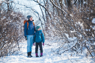 Woman with a child on a winter hike in the mountains.
