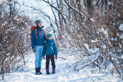 Konstfotografi Woman with a child on a winter hike in the mountains.