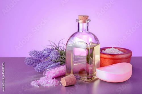 Spa setting with natural oil, soap, sea salt and lavender flowers.