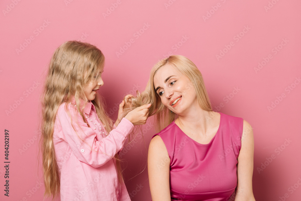 mother with daughter in pink clothes on a pink background mother with daughter in pink clothes on a pink background