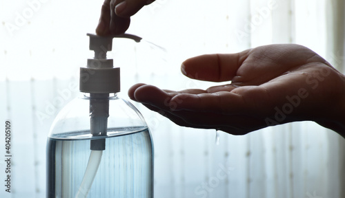 Hands pressing on a sanitizer gel bottle to prevent covid-19