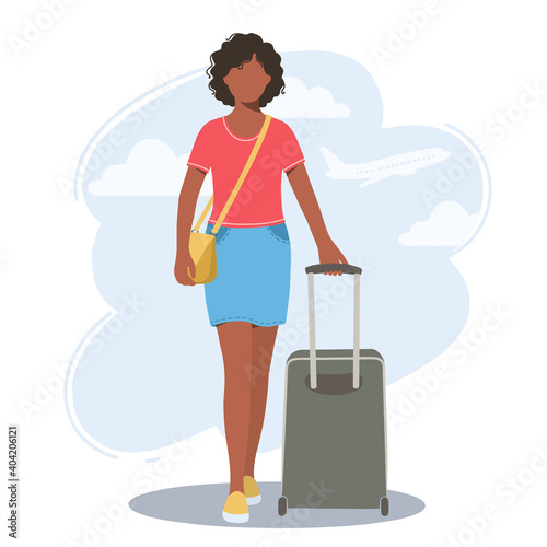 Beautiful young African-American woman with a suitcase in her hands. The concept of travel, tourism and recreation.