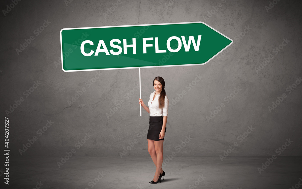 Obraz premium Young business person in casual holding road sign with CASH FLOW inscription, new business direction concept