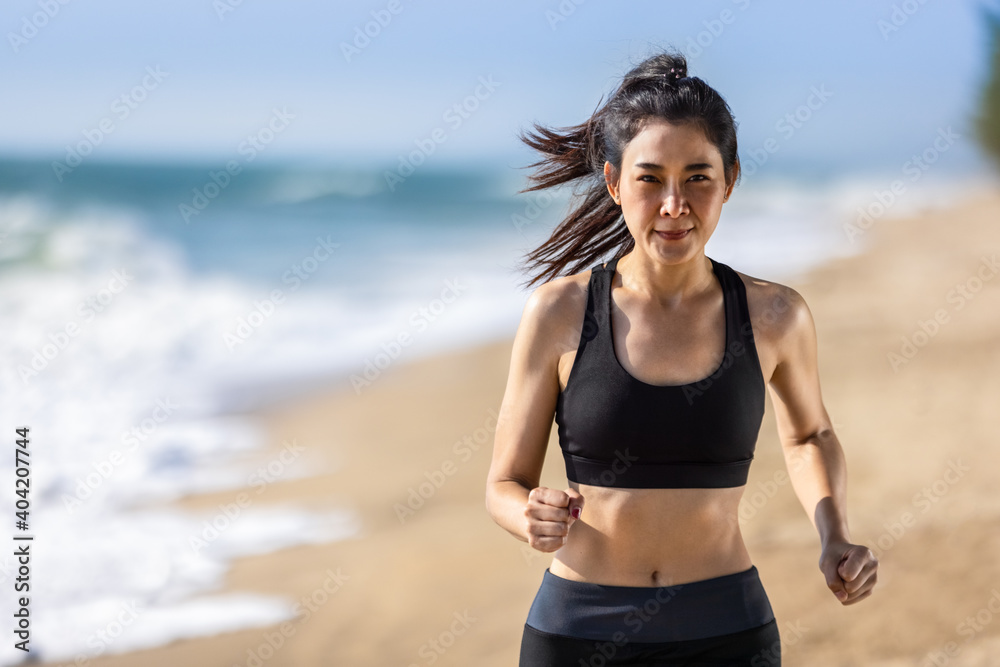 Asian healthy athletic muscle woman running on beach Asian healthy athletic muscle woman running on beach