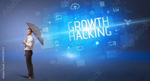 Businessman defending with umbrella from cyber attack and GROWTH HACKING inscription, online security concept