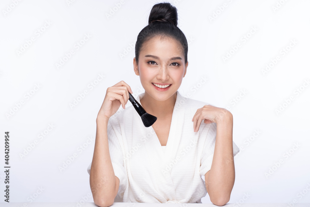 Portrait of woman applying dry cosmetic foundation on the face using makeup brush. Girl without makeup with clean skin with a makeup brush in hand. Cute woman face with fresh clean flawless skin. Portrait of woman applying dry cosmetic foundation on the face using makeup brush. Girl without makeup with clean skin with a makeup brush in hand. Cute woman face with fresh clean flawless skin.