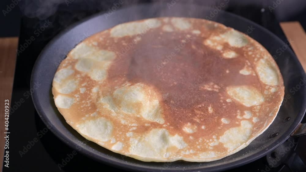 Traditional thin Russian pancakes on a plate, a woman greases with butter. Baking for carnival in russia. High quality 4k footage