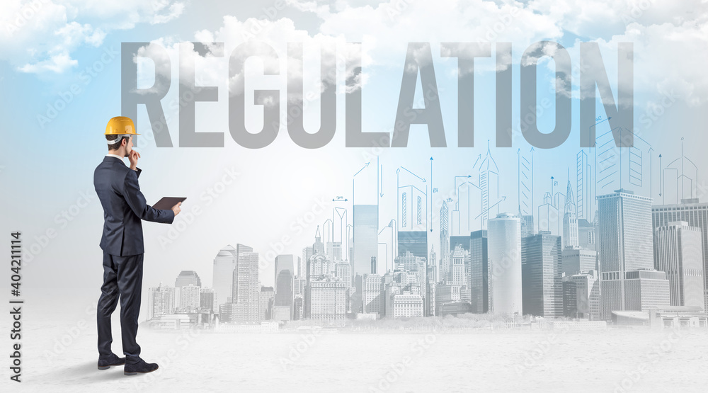 Young businessman with hard hat and REGULATION inscription, new business opportunity concept Young businessman with hard hat and REGULATION inscription, new business opportunity concept