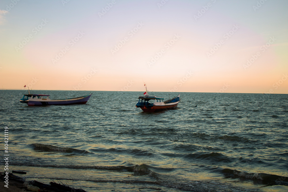 Naklejka premium fishing boat at sunset