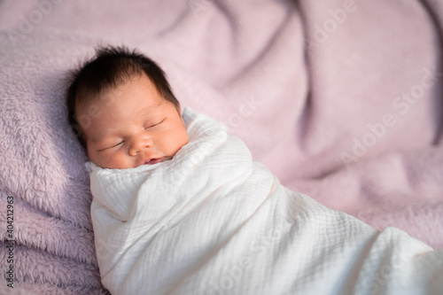portrait of baby infant sleeping on soft furry bed in studio.