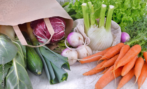 vegetables in a reusable  and paper bags among other  fresh vegetables  on a ...