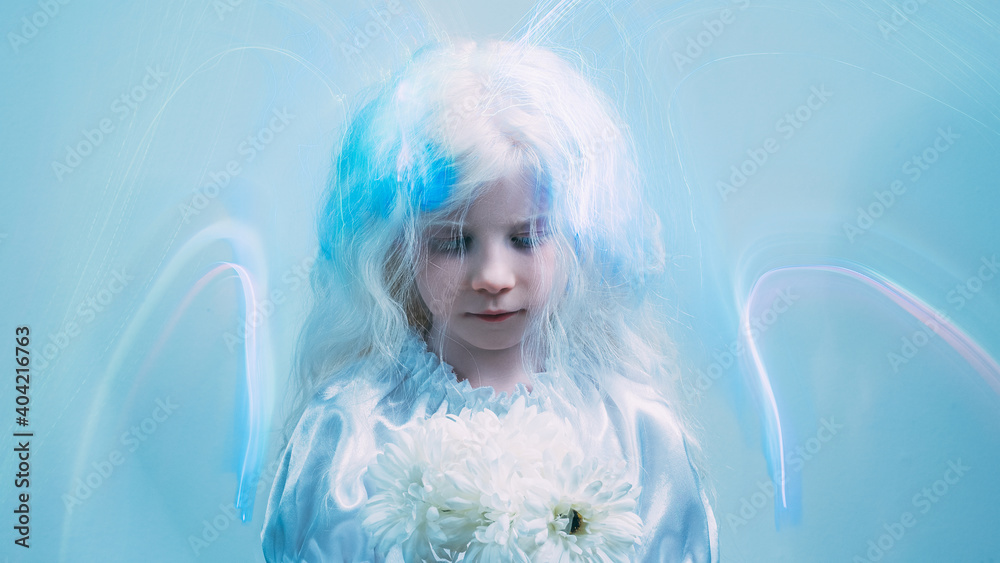Angel girl. Child art portrait. Heaven blessing. Ethereal aura. Sweet blonde little kid with white flowers in blur iridescent fluorescent glow strokes on blue copy space background.