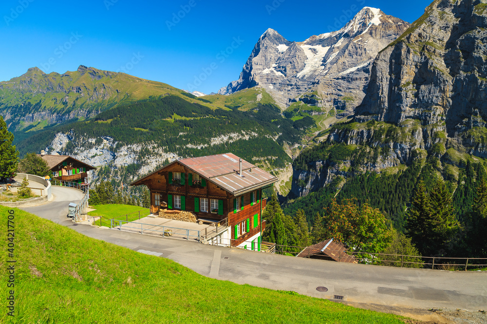Obraz premium Wooden houses and high snowy mountains, Murren mountain resort, Switzerland