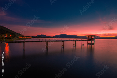 The background of the bridge stretches into the sea, with twilight light in the morning, beautiful colors, sky wallpaper and refreshing surroundings. © bangprik