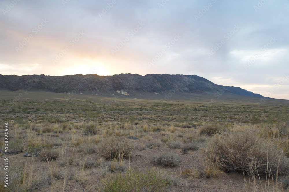 Almaty, Kazakhstan - 06.25.2013 : Dawn over the mounds in a sandy and rocky area in the Altyn Emel Nature Reserve