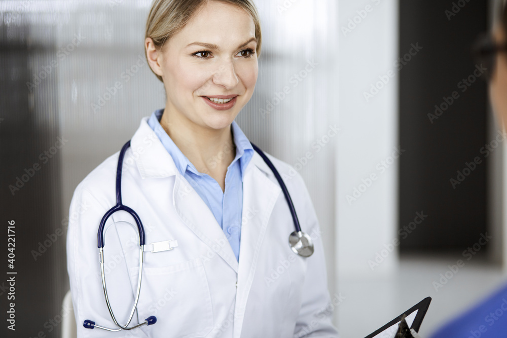 Friendly female doctor and patient man discussing current health examination while sitting in clinic. Perfect medical service in hospital. Medicine and healthcare concept Friendly female doctor and patient man discussing current health examination while sitting in clinic. Perfect medical service in hospital. Medicine and healthcare concept
