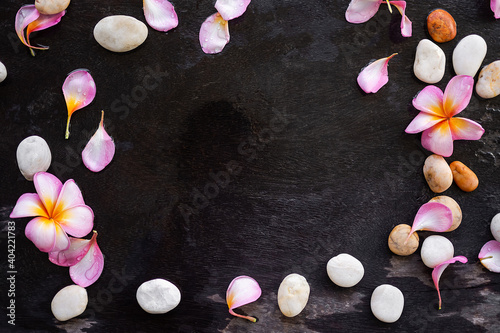 Plumeria flowers aromatherapy spa set with pebbles on wooden background.frame flat lay with copy space.