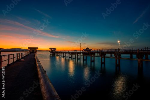 The background of the bridge stretches into the sea, with twilight light in the morning, beautiful colors, sky wallpaper and refreshing surroundings.